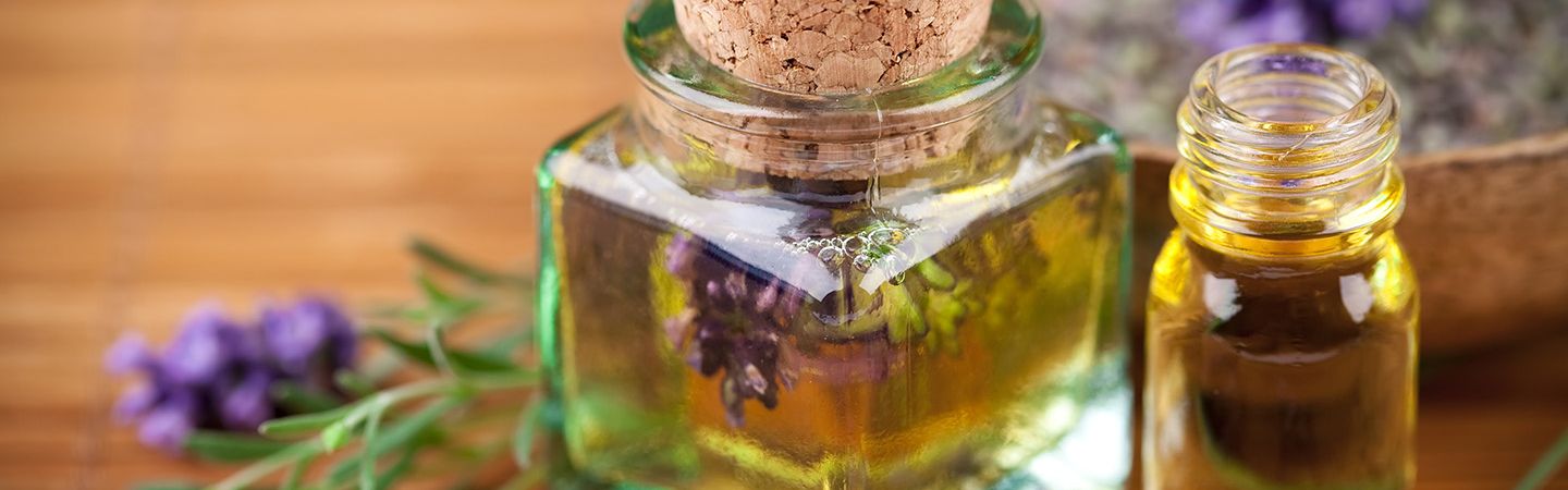 Öl und Honig in einem Glas - dazu Lavendelblüten